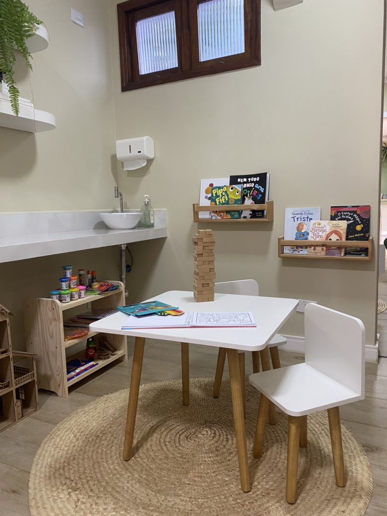 Cantinho infantil no espaço do In Lumina, com mesinha, livros e brinquedos